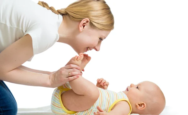 Happy-mother-having-fun-with-her-infant-after-massage-session-at-home