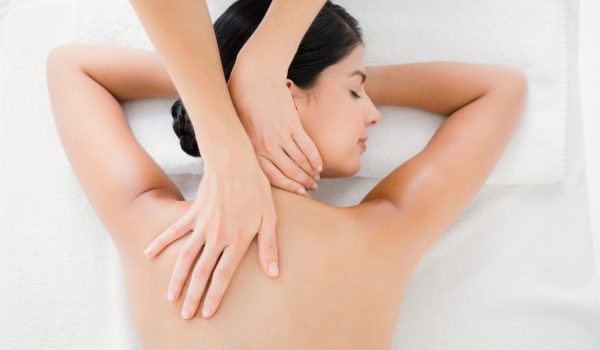 Upward view of woman receiving back massage at spa center